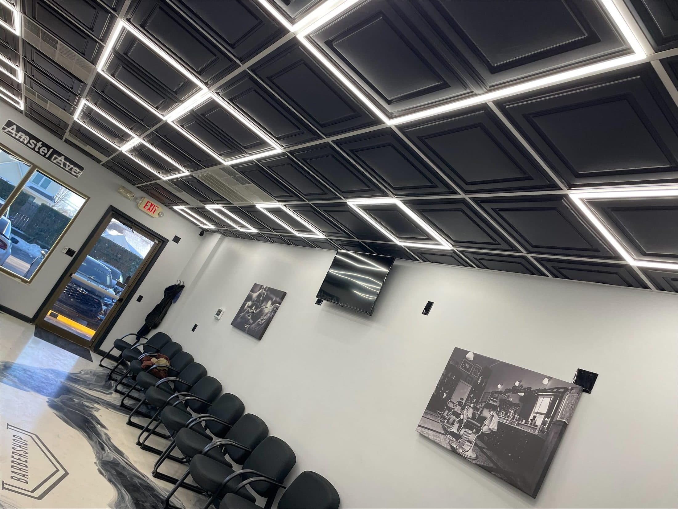 Amstel Barber Shop with a grid of linear LED fixtures across a black ceiling