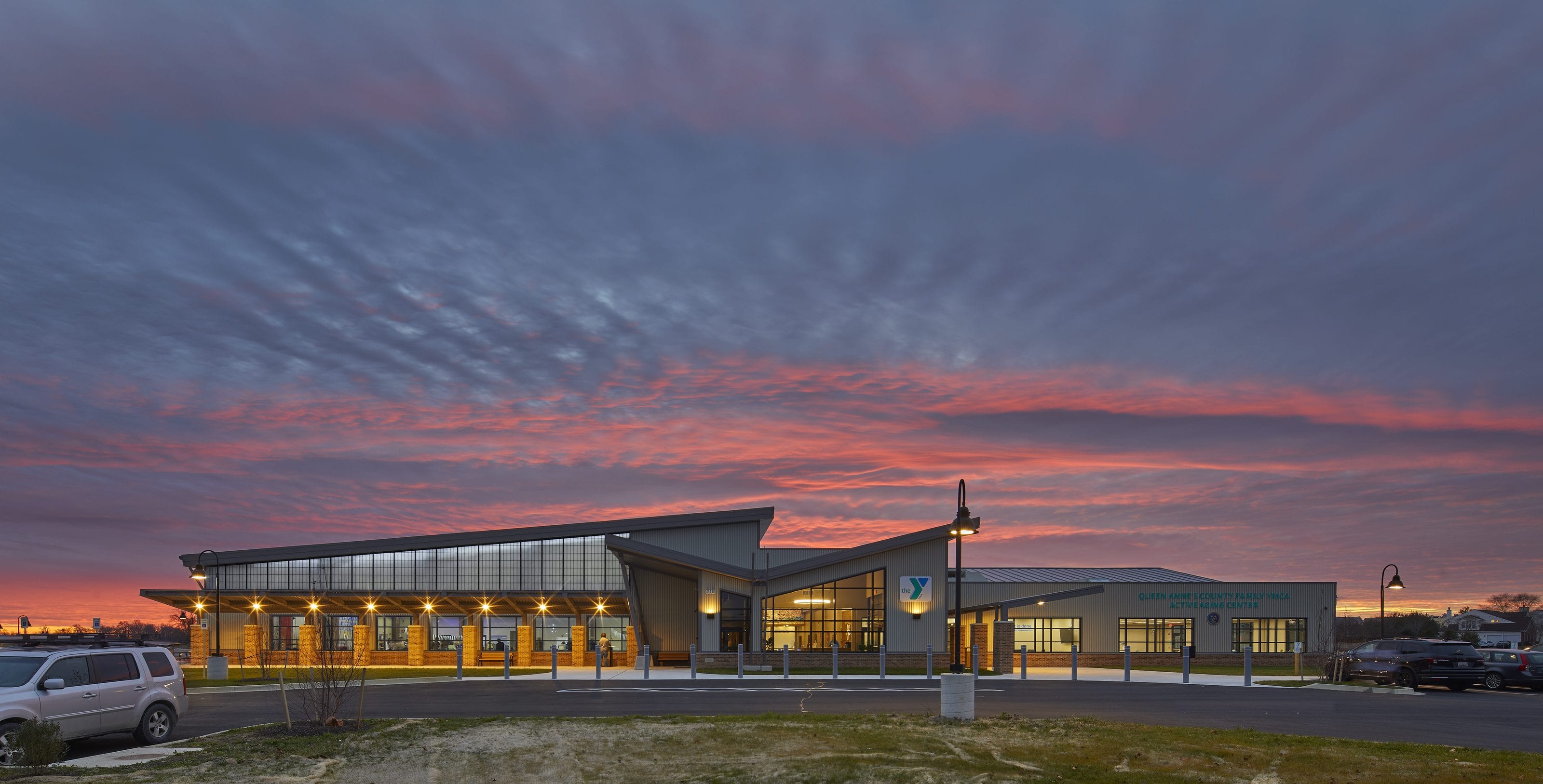 Queen Anne's County Family YMCA lit up at dusk under a red sky